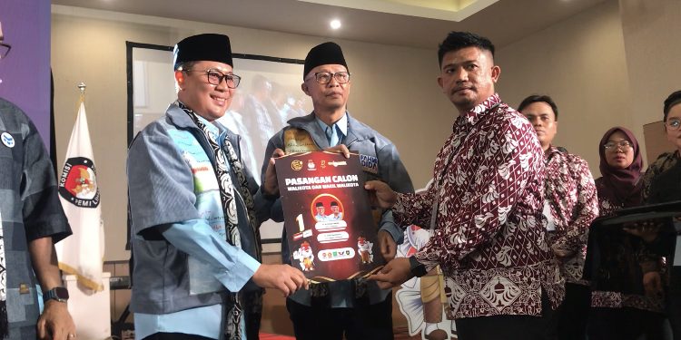 Ketua KPU Kota Sukabumi, Imam Sutrisno, saat menyerahkan berkas nomor urut 1 kepada paslon Walikota dan Wakil Walikota Sukabumi, Achmad Fahmi-Dida Sembada, pada Senin (23/9/2024).