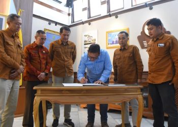Pj Wali Kota Sukabumi, Kusmana Hartadji, saat menandatangani surat pengantar rekomendasi UMK tahun 2025 di ruang utama Balai Kota.
