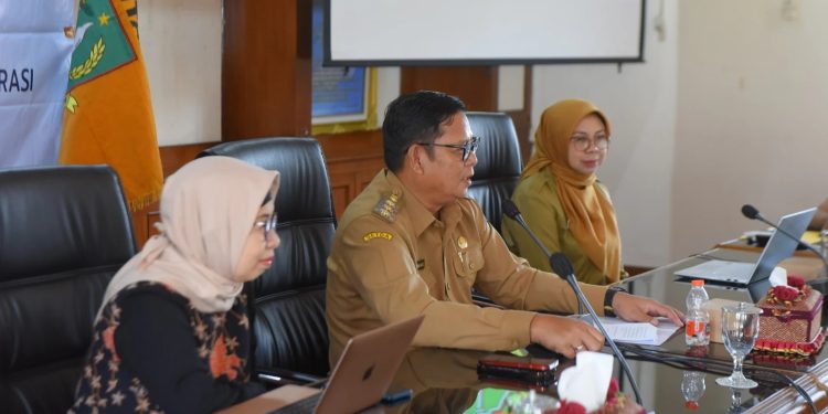 Pj Wali Kota Sukabumi, Kusmana Hartadji, memberikan sambutan dalam sosialisasi dan koordinasi penguatan kolaborasi pengelolaan sampah di Oproom Balai Kota Sukabumi, pada Senin (16/12/2024).