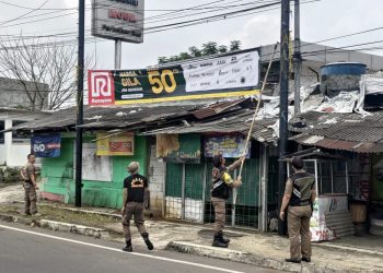 Anggota Dinas Satpol PP dan Damkar Kota Sukabumi menertibkan reklame di ruas Jalan Pelda Suryanta, Kecamatan Citamiang, pada beberapa waktu lalu. Foto: Istimewa.