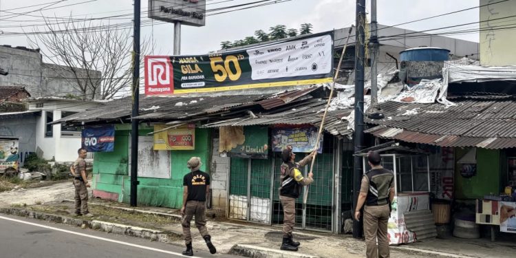 Anggota Dinas Satpol PP dan Damkar Kota Sukabumi menertibkan reklame di ruas Jalan Pelda Suryanta, Kecamatan Citamiang, pada beberapa waktu lalu. Foto: Istimewa.