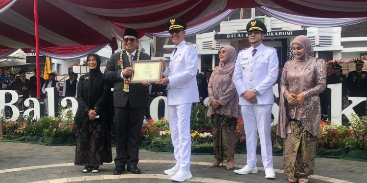 Wali Kota Sukabumi, H. Ayep Zaki, saat menerima piagam penghargaan dari Pj Wali Kota Sukabumi, Kusmana Hartadji, dalam kegiatan sertijab di di Plaza Balai Kota Sukabumi pada Kamis, (20/2/2025). Foto: Nuria Ariawan/katasukabumi