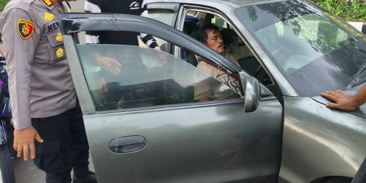 Kapolsek Citamiang, AKP Heri Hermawan, akan melakukan evakuasi seorang warga yang tidak sadarkan diri saat mengemudi di sekitar Jalan Pramuka, Kecamatan Citamiang. Foto: Istimewa.